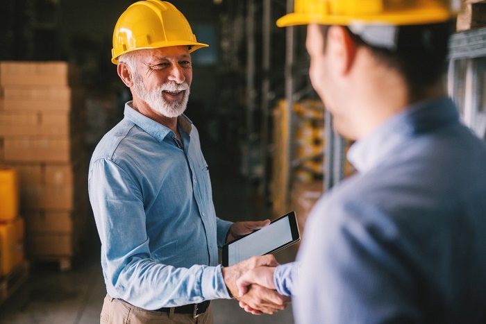 Men shake hands in warehouse
